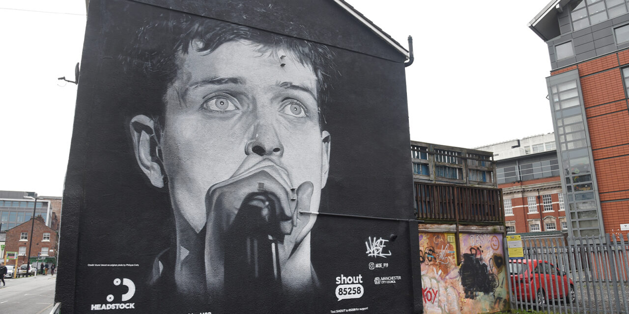 Outrage Across Manchester as Ian Curtis Mural is Replaced by Aitch’s Album Advertisement